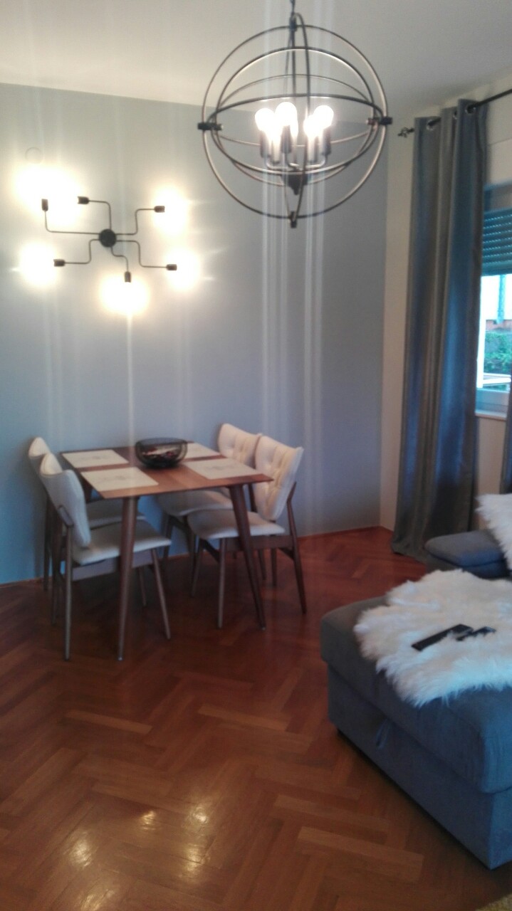 Wohnzimmer mit Essbereich in einer Wohnung, Herceg Novi, Montenegro: Parkett, Designerleuchten und Polstermöbel.