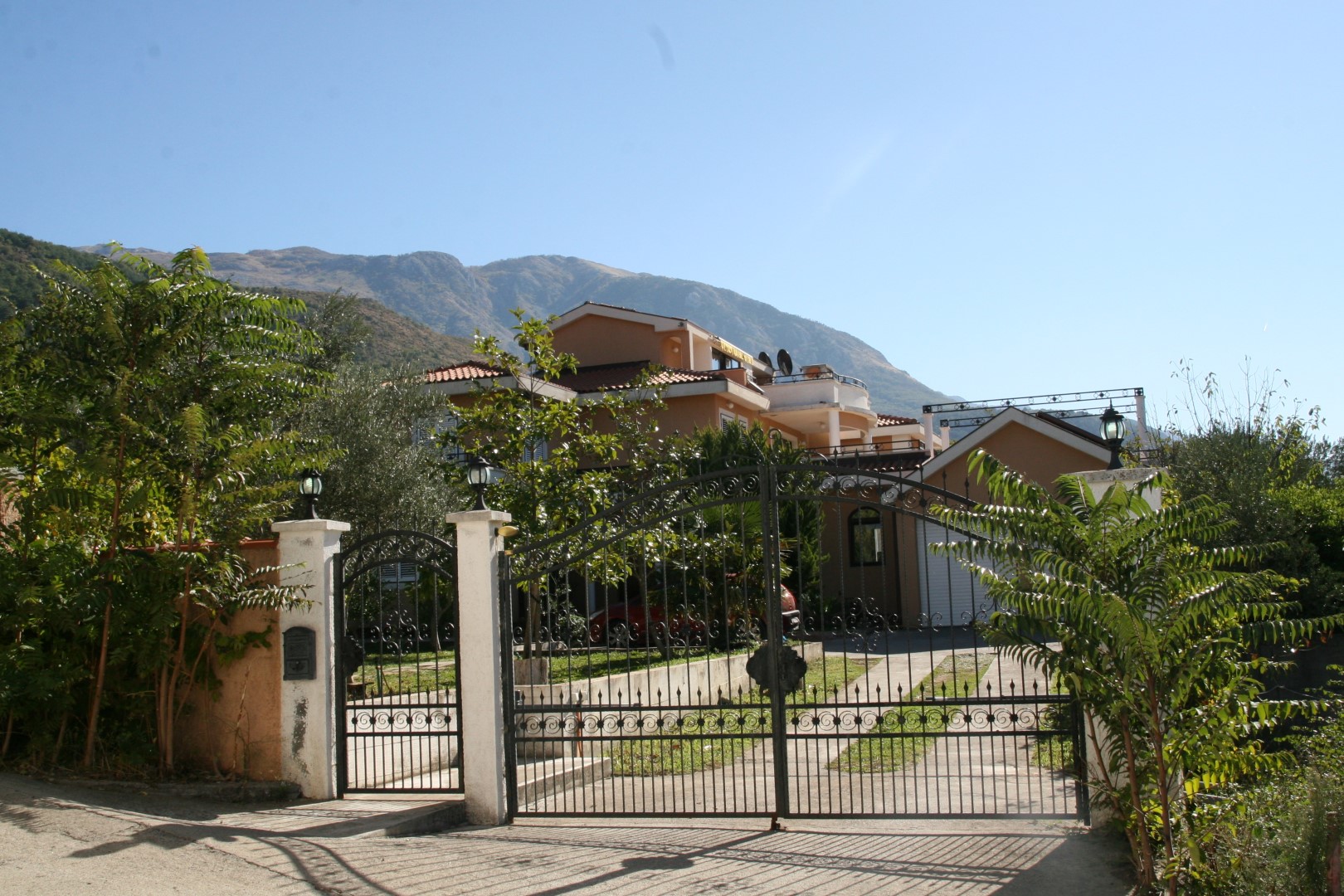 Dvospratna vila sa kovanim kapijama i pogledom na planine u Kavaču, Bokokotorski zaliv, Crna Gora.