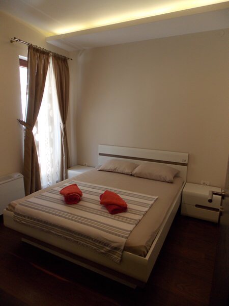 Gemütliches Schlafzimmer mit Doppelbett in einer Wohnung in Budva, Montenegro: moderne Möbel und helles Interieur.
