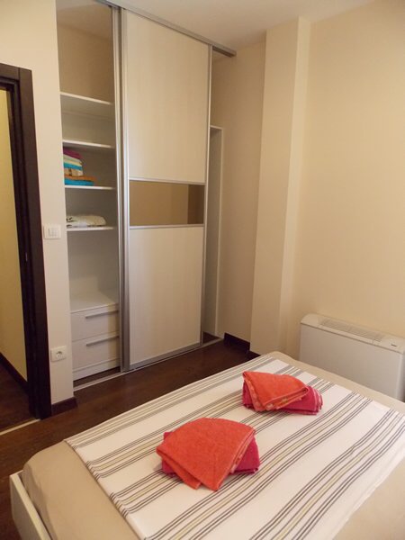 Schlafzimmer in einer Wohnung in Budva, Montenegro: Doppelbett, Einbauschrank und helle Innenausstattung.