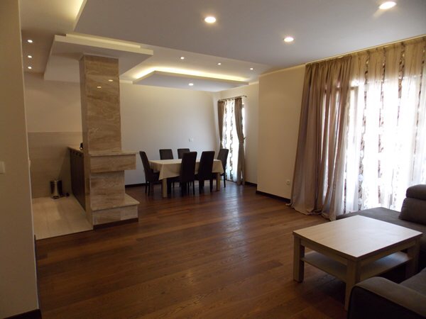 Geräumiges Wohnzimmer mit Essbereich und Marmorverkleidung in einer Wohnung in Budva, Montenegro. Modernes Interieur.