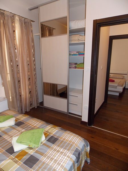 Schlafzimmer in einer Wohnung in Budva, Montenegro: Doppelbett, Einbauschrank und Blick in das benachbarte Zimmer.