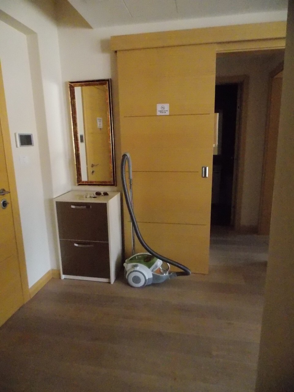 Predsoblje u stanu u Budvi, Crna Gora: klizna unutrašnja vrata, ogledalo i ormarić za obuću u enterijeru.