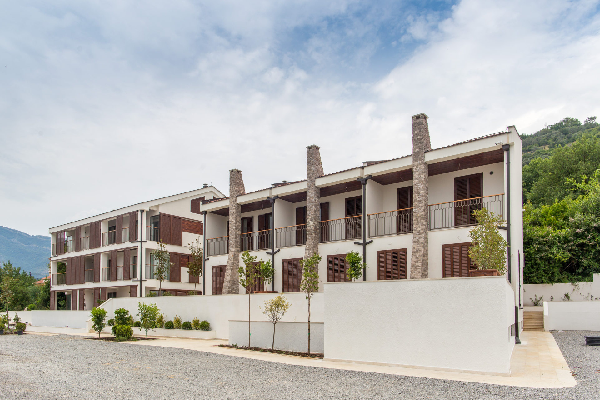 Moderner Wohnkomplex mit Terrassen und Steinverkleidung in Tivat, Montenegro: Blick auf die Fassaden der Gebäude mit Balkonen.