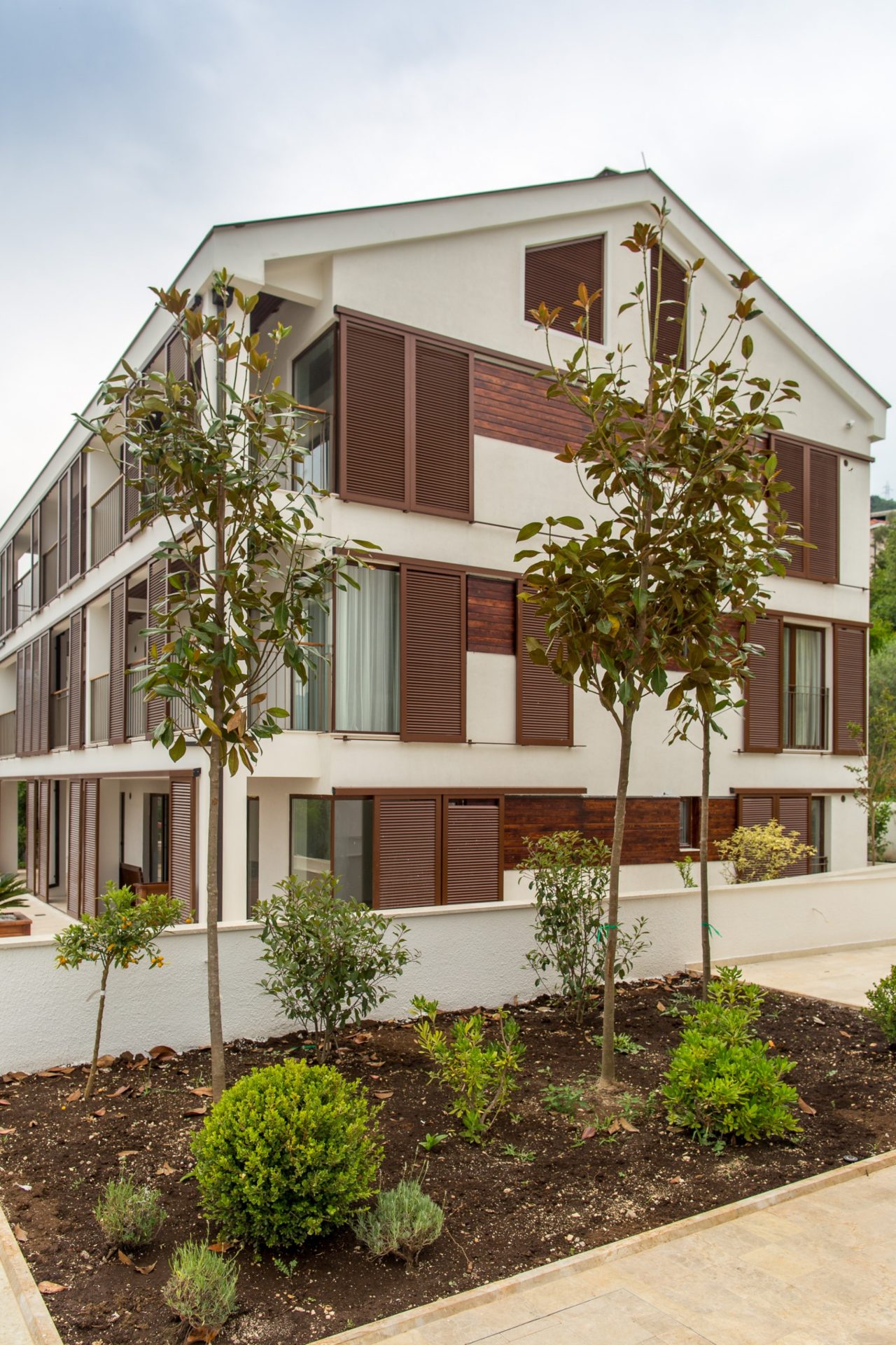 Modernes Wohnhaus mit Terrassen und Holzläden in Tivat, Montenegro, umgeben von einem gepflegten Garten.