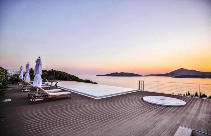 Terrasse mit Infinity-Pool, Whirlpool und Meerblick in Kamenovo, Montenegro: Sonnenliegen und Lounge-Bereich bei Sonnenuntergang.