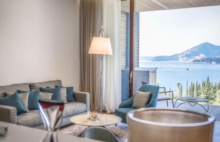 Wohnzimmer in einer modernen Wohnung in Kamenovo, Montenegro, mit Panoramablick auf das Meer und einer möblierten Terrasse.