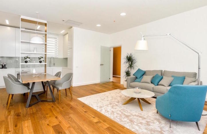 Modernes Wohnzimmer mit Küche in einer Wohnung in Kamenovo, Montenegro: helles Interieur, weiche Möbel und Essbereich.