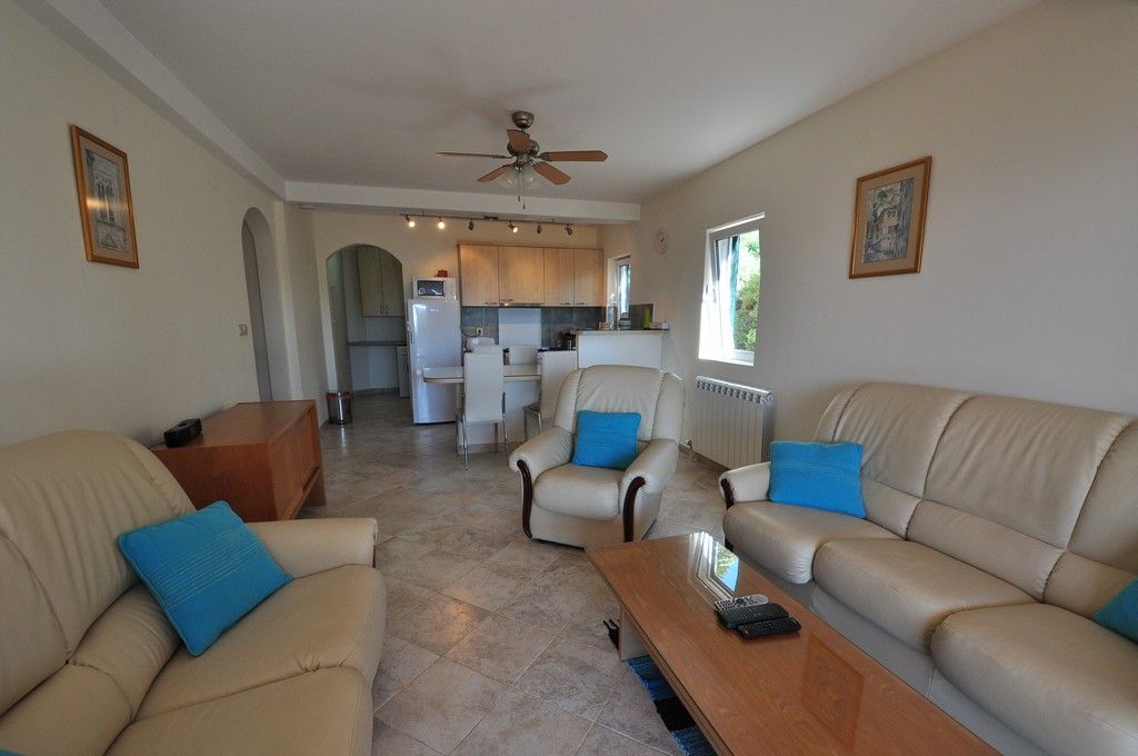 Wohnzimmer mit Ledermöbeln und Küche in einer Villa in Tivat, Montenegro: helles Interieur, Fliesenboden und Deckenventilator