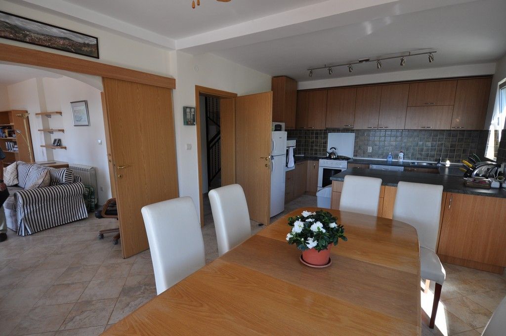 Innenraum der Küche mit Essbereich und Holz-Einbauküche in einer Villa in Tivat, Montenegro.