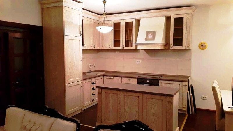 Karadağ, Krimovitsa’daki villada ahşap mutfak dolabı ve adalı aydınlık mutfak. Klasik tarzda iç mekan.