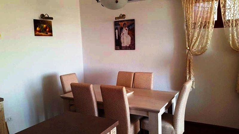 Karadağ, Krimovitsa’daki villanın oturma odasında ahşap masa ve sandalyelerle уютlu bir yemek alanı.