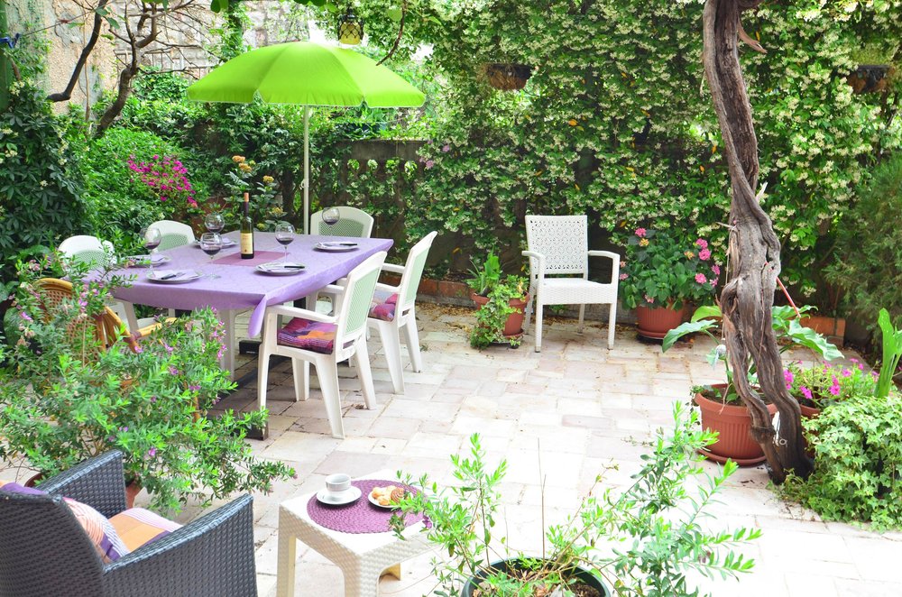 Gemütliche Terrasse mit Essbereich und Garten im Haus, Herceg Novi, Montenegro: gepflasterte Fläche, Möbel und viel Grün.