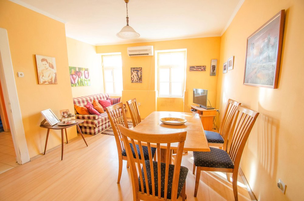 Gemütliches Wohnzimmer mit Essbereich im Haus, Herceg Novi, Montenegro: Holztisch, Stühle und ein weiches Sofa.