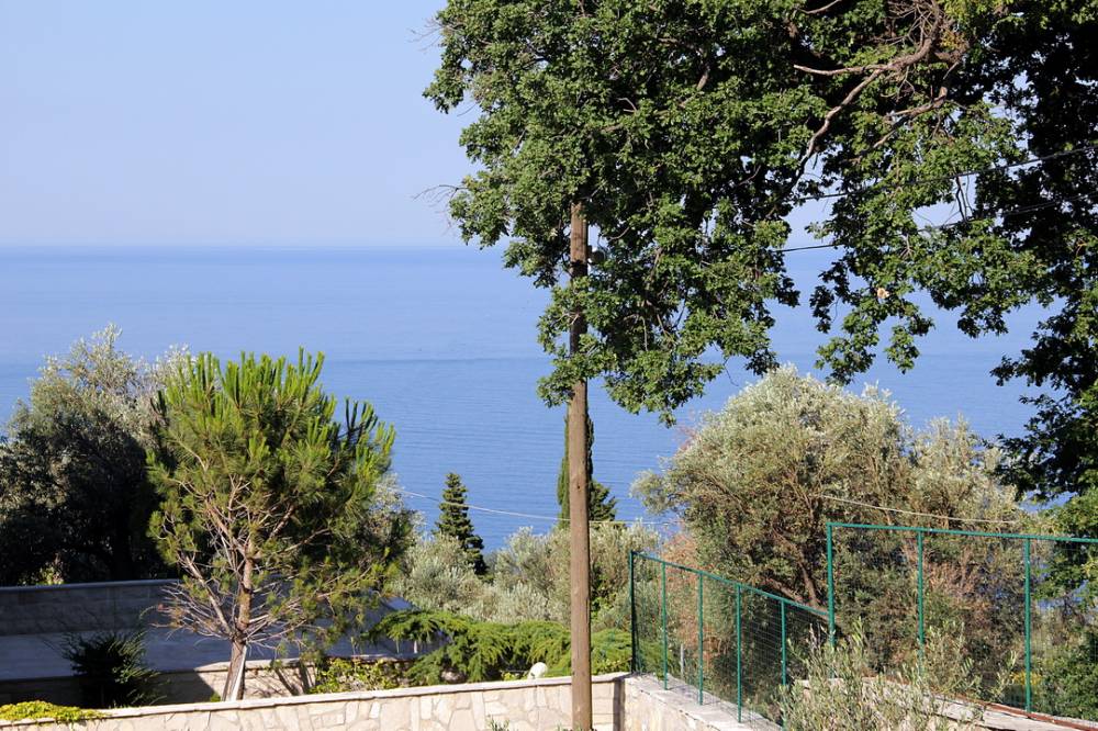 Reževići’deki evden Adriyatik Denizi’nin panoramik manzarası, Budva Rivierası, Karadağ; yeşillikler ve ağaçlar arasında.