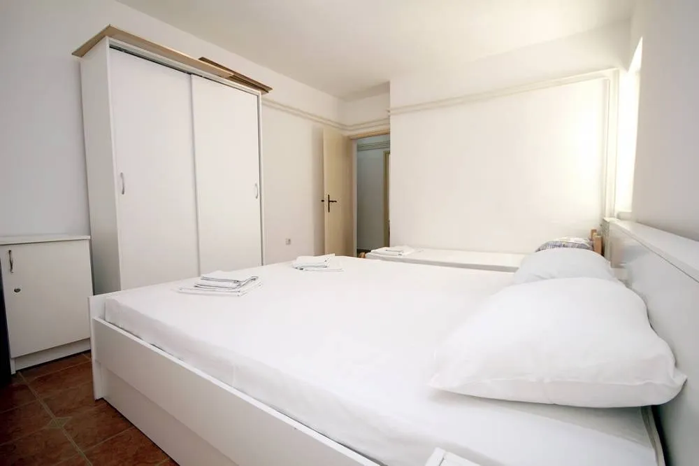 Helles Schlafzimmer mit Doppelbett und Kleiderschrank in einem Haus an der Budva-Riviera, Montenegro.