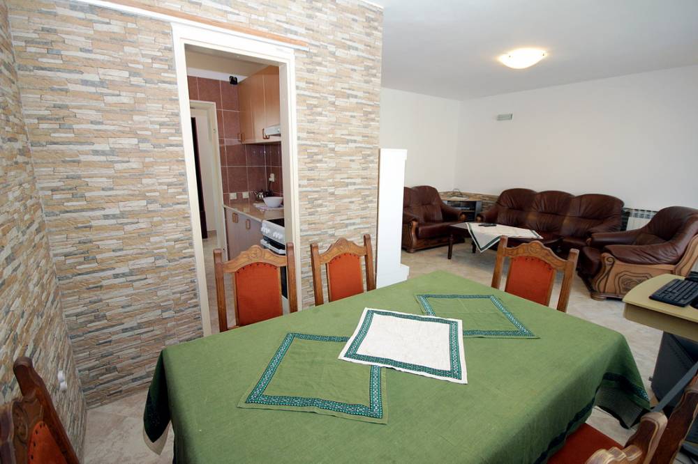 Reževići, Budva Rivierası, Karadağ’daki evde yemek alanı ve taş kaplamalı oturma odası.