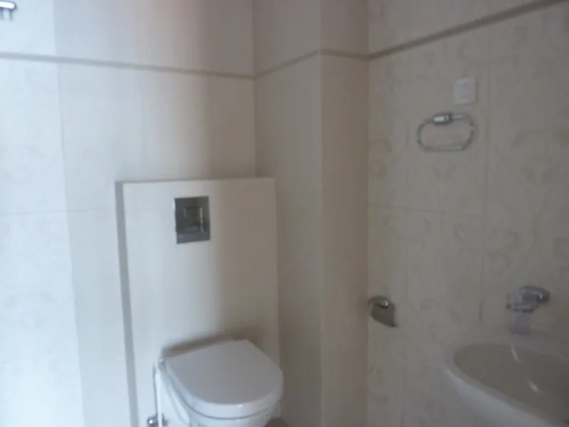 Modernes Badezimmer mit Hänge-WC und heller Fliese in einer Wohnung in Pržno, Montenegro.