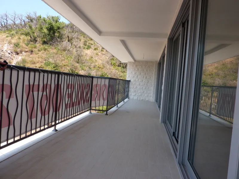 Geräumiger Balkon mit Panoramablick auf die Berge in einer Wohnung in Pržno, Montenegro: moderne Ausstattung und Geländer.