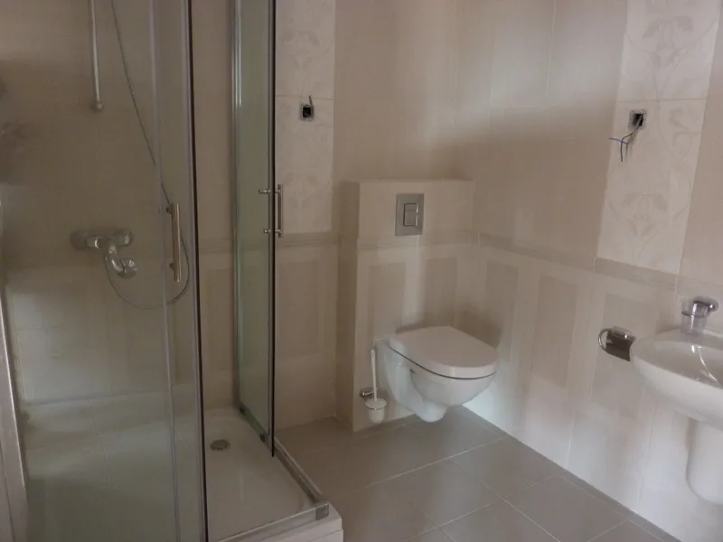 Badezimmer mit Duschkabine und Hänge-WC in einer Wohnung, Pržno, Montenegro: moderne helle Ausstattung.