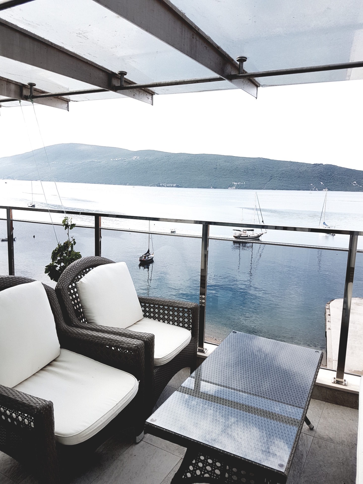 Taras z plecionymi meblami i panoramicznym widokiem na morze oraz jachty w Herceg Novi, Czarnogóra. Apartament nr 1258.