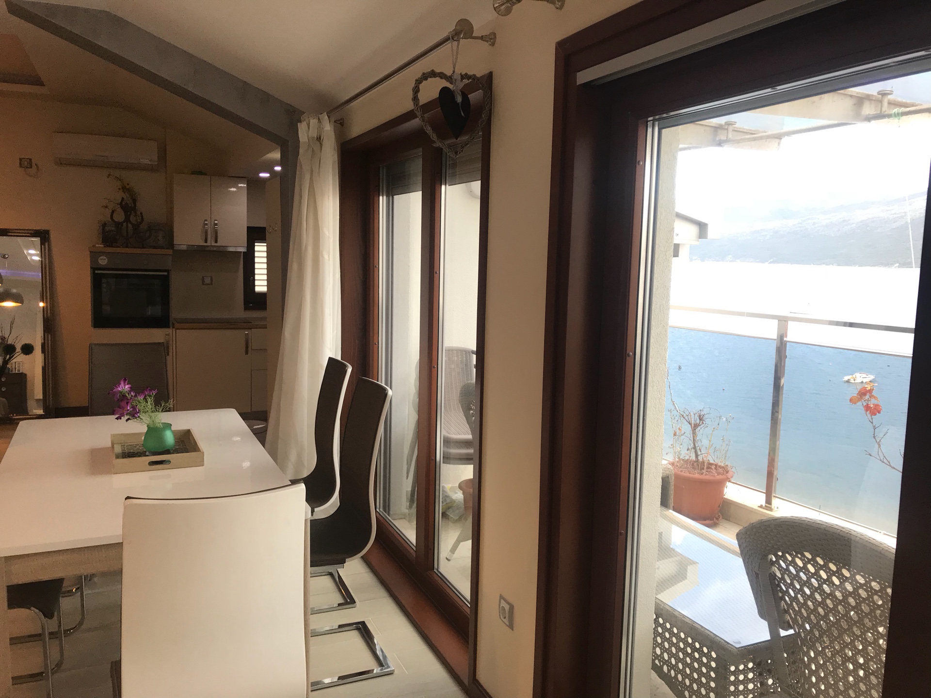 Salon z jadalnią i panoramicznym widokiem na morze w apartamencie w Herceg Novi, Czarnogóra.