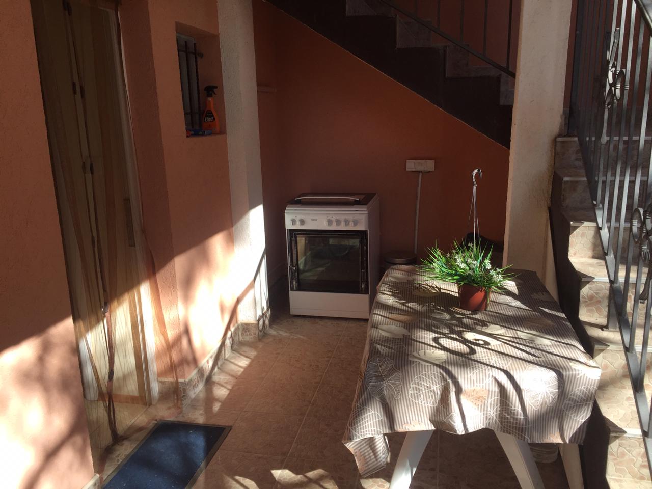 Sommerküche auf der Terrasse des Hauses in Šušanj, Montenegro: Herd, Esstisch und Treppe ins zweite Stockwerk.