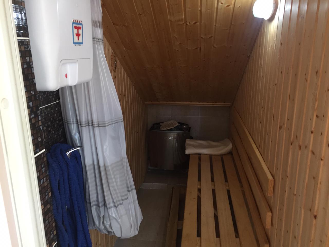 Heimsauna mit Holzverkleidung und Harvia-Ofen im Haus in Šušanj, Montenegro. Badezimmer mit Dusche.