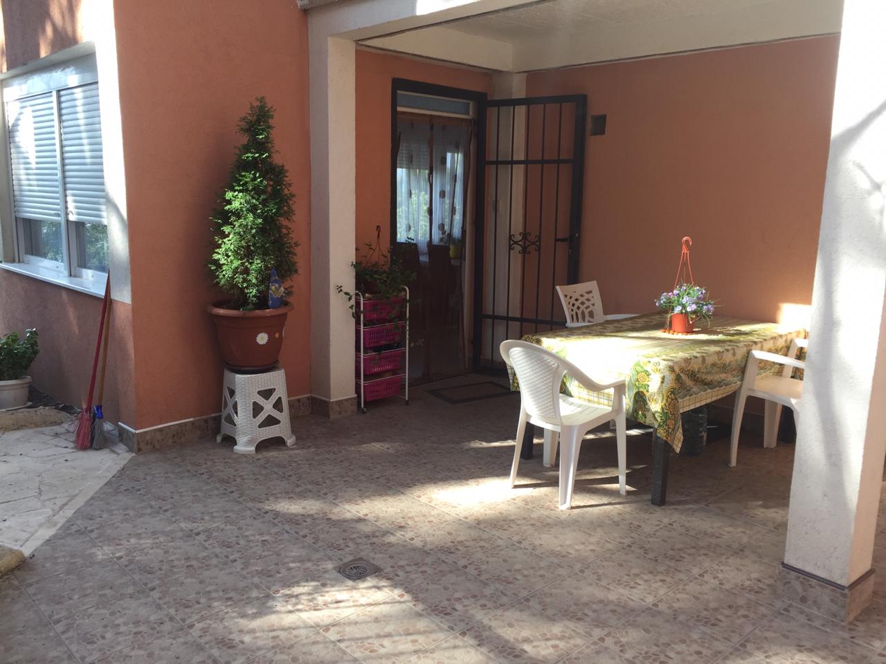 Gemütliche Terrasse mit Essbereich und Gartenmöbeln am Haus in Šušanj, Montenegro. Blick auf den Eingangsbereich und den Hof.