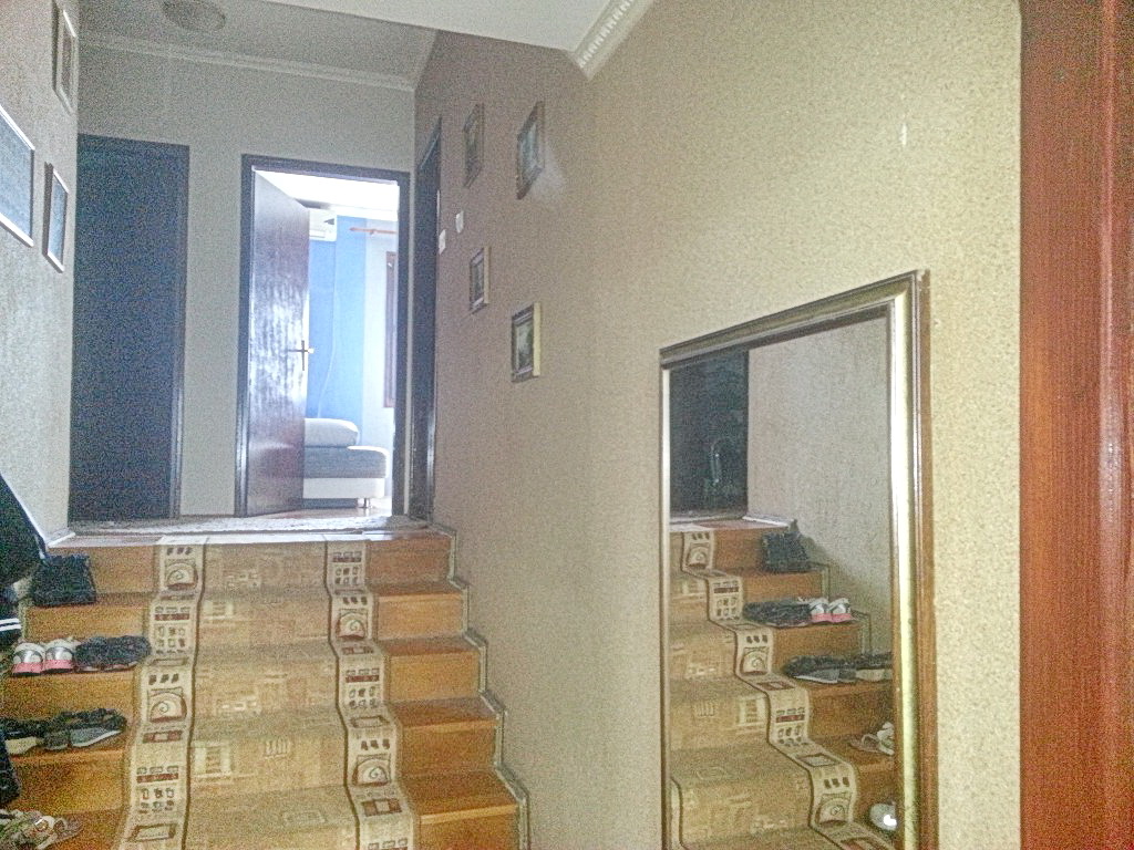 Predsoblje sa drvenim stepeništem i ogledalom u kući, Herceg Novi, Crna Gora. Pogled na unutrašnja vrata i enterijer.