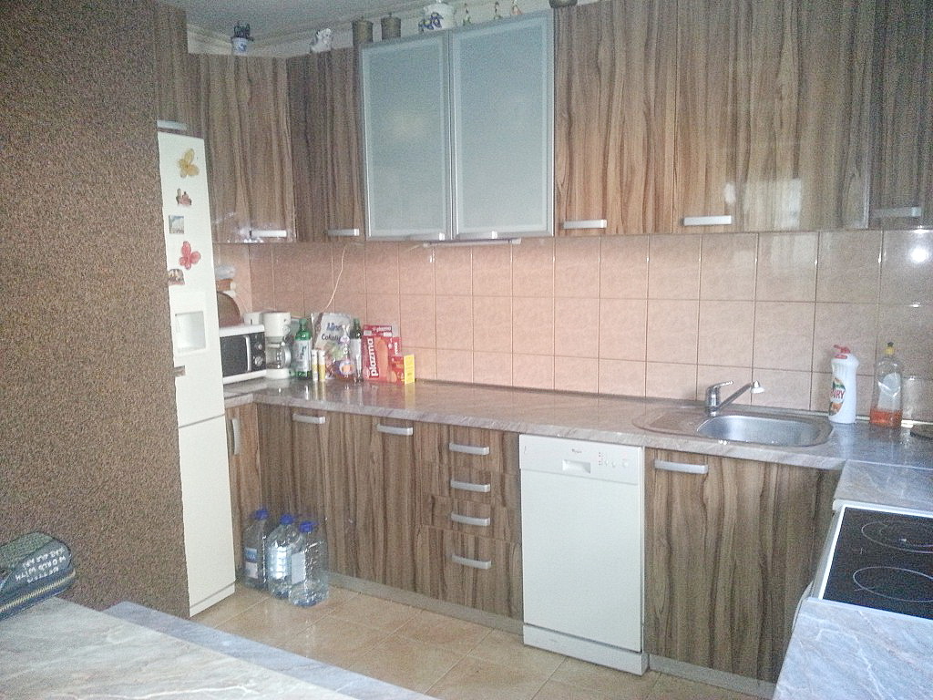 Kuhinja sa drvenim frontovima i ugradnom tehnikom u kući u Herceg Novom, Crna Gora: pogled na radnu zonu i šporet.
