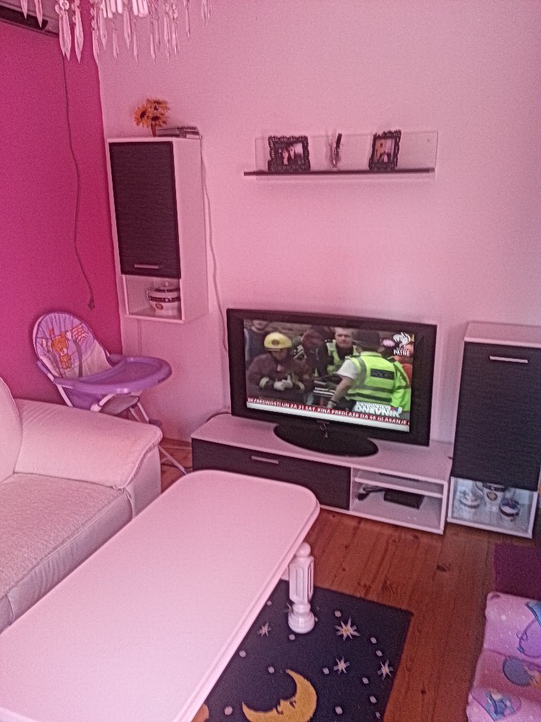 Dnevna soba u kući u Herceg Novom, Crna Gora: svetao nameštaj, televizor, drveni pod i jarki akcenti u enterijeru.