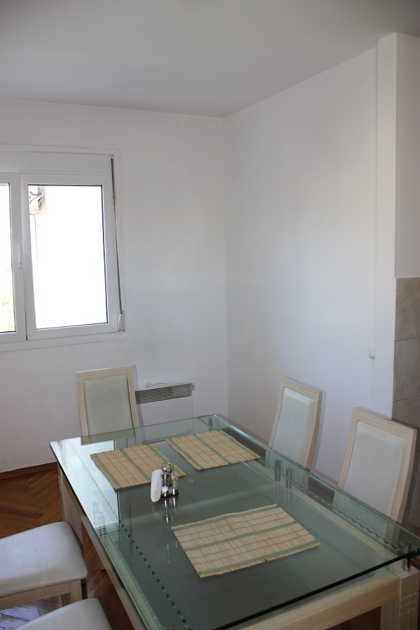 Heller Essbereich mit Glastisch in einer Wohnung, Budva, Montenegro: Wohnzimmerinterieur mit weißen Wänden.