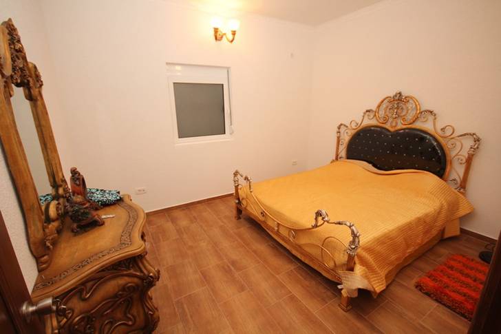 Satılık evde ferforje yatak ve oymalı şifonyerli yatak odası, Dobri Vody, Karadağ. Fayanslı aydınlık iç mekan.