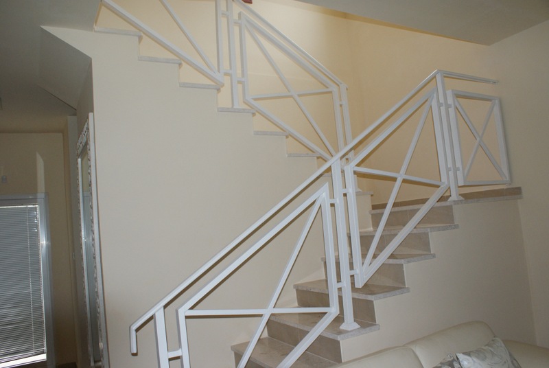 Treppe mit weißen Metallgeländern im Innenraum eines Hauses in Bigovo, Montenegro: moderne Steinverkleidung.