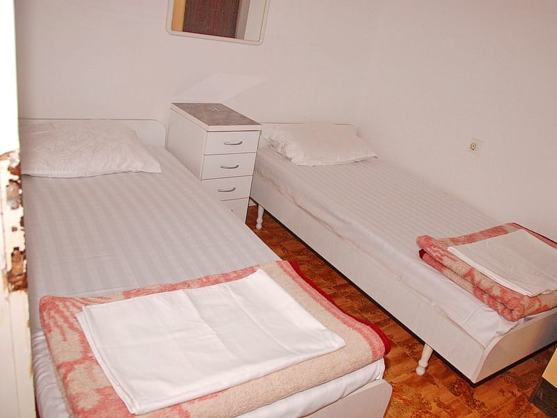 Chambre avec deux lits simples et une table de chevet dans une maison à vendre, Igalo, Monténégro.