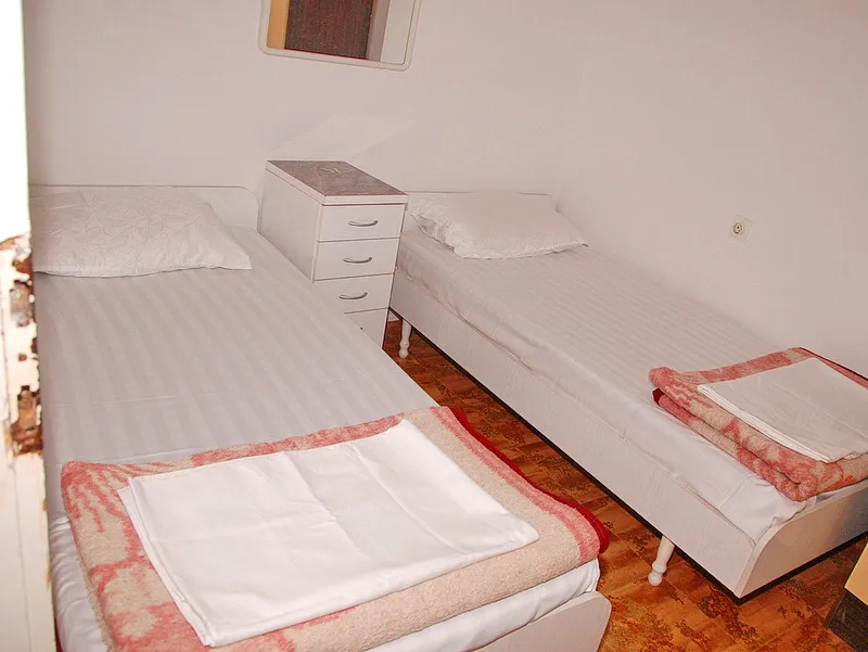 Chambre avec deux lits simples et une table de chevet dans une maison à vendre, Igalo, Monténégro.