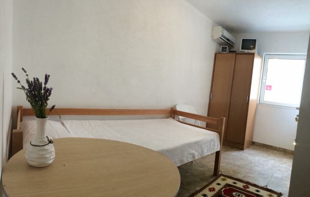 Spavaća soba u mini-hotelu Meline, Bokokotorski zaliv, Crna Gora: drveni krevet, ormar, sto i pogled kroz prozor.