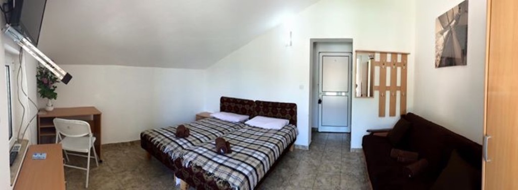 Spavaća soba u mini-hotelu Meline, Bokokotorski zaliv, Crna Gora: dva kreveta, sofa, radni sto i pločice na podu.