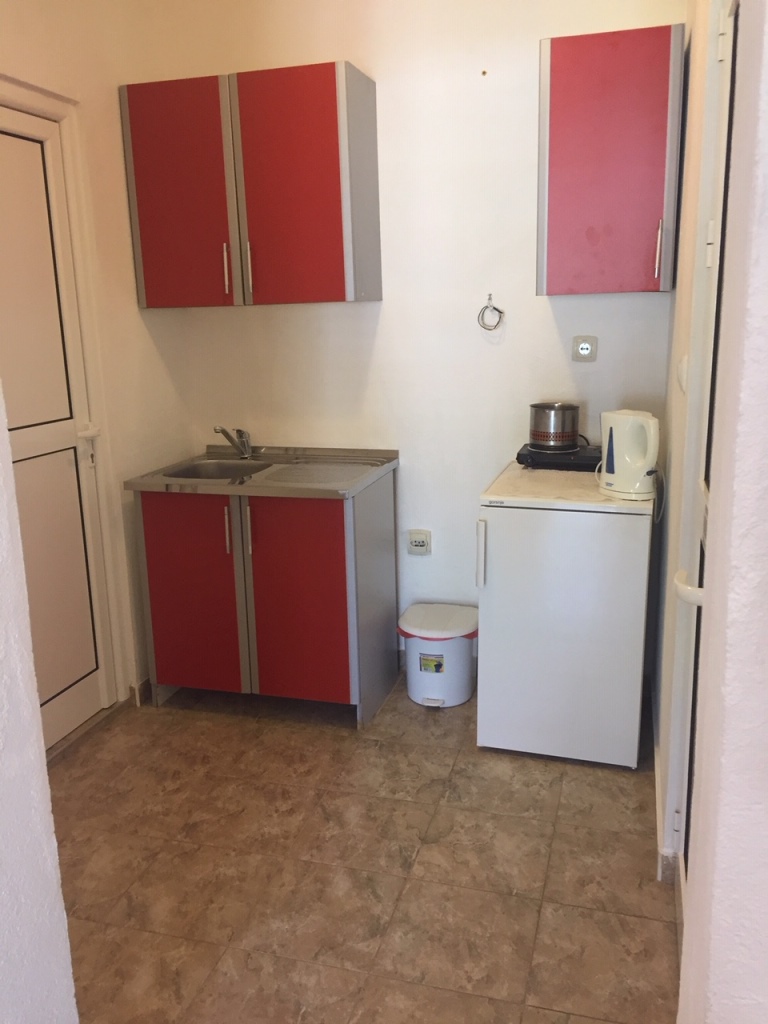 Kompaktna kuhinja sa crvenim frontovima i kućnim aparatima u mini-hotelu, Meline, Bokokotorski zaliv, Crna Gora.