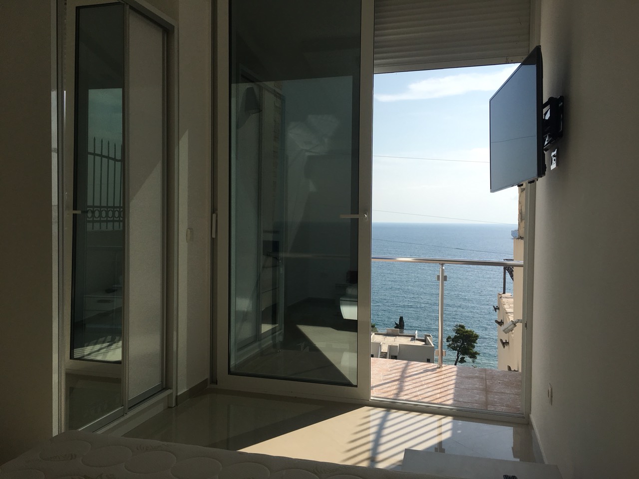 Schlafzimmer mit Panoramablick auf das Meer und Zugang zum Balkon in einem Haus, Šušanj, Bar-Riviera, Montenegro.