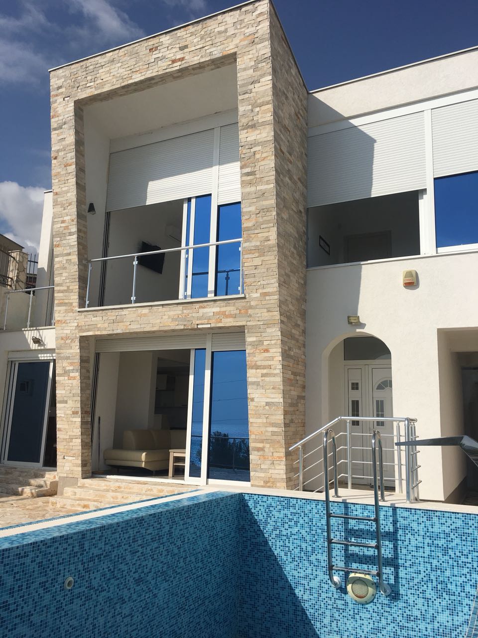 Moderne Villa mit Pool und Steinverkleidung in Šušanj, Bar Riviera, Montenegro: Blick auf die Terrassen und die Fassade des Hauses.