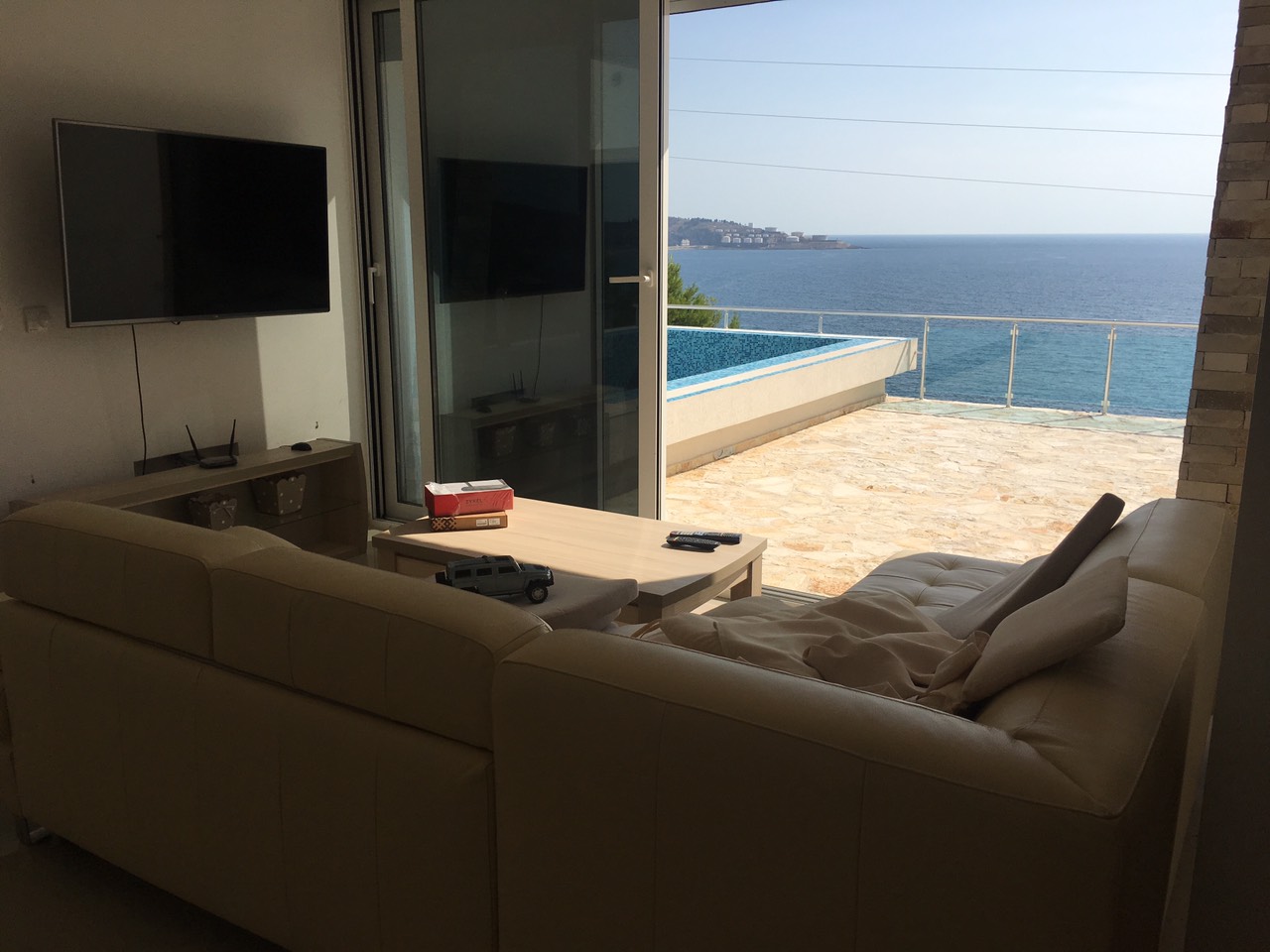 Wohnzimmer mit Ledersofa und Terrasse mit Pool und Meerblick in einem Haus, Šušanj, Bar Riviera, Montenegro.