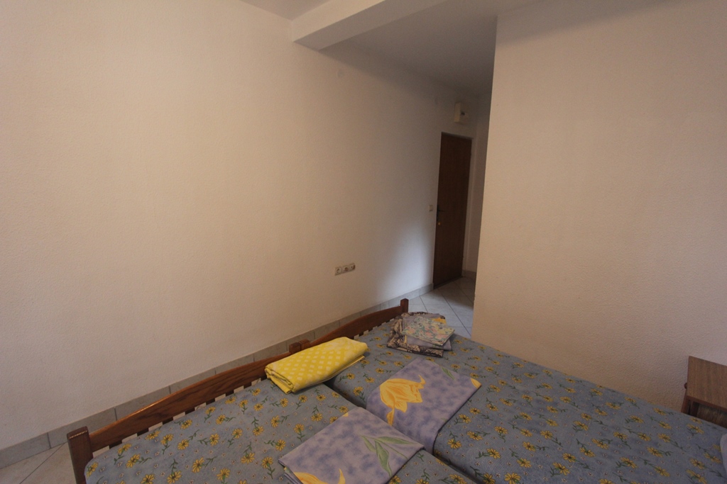 Schlafzimmer mit zwei Einzelbetten in einem Mini-Hotel, Baošići, Montenegro: helle Einrichtung und Holzmöbel.