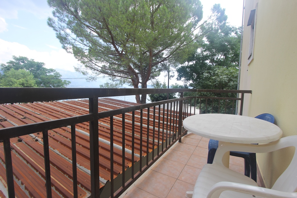 Balkon mit Kunststoffmöbeln und Blick auf das Meer und die Bäume in einem Mini-Hotel, Baošići, Montenegro.
