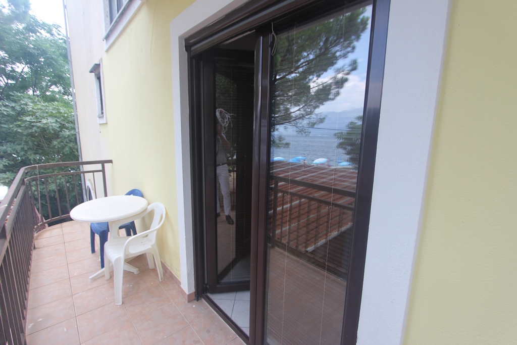Balkon mit Kunststoffmöbeln im Mini-Hotel Baošići, Montenegro, mit Panoramablick auf das Meer und den Strand.