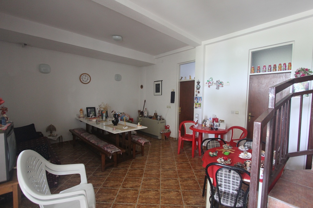 Geräumiges Wohnzimmer mit Essbereich in einem Mini-Hotel, Baošići, Montenegro: Fliesenboden, Holzmöbel und Treppe.