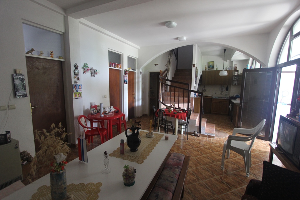 Wohnzimmer mit Essbereich und Treppe in einem Mini-Hotel, Baošići, Montenegro: Innenraum mit Fliesen und Holztüren.