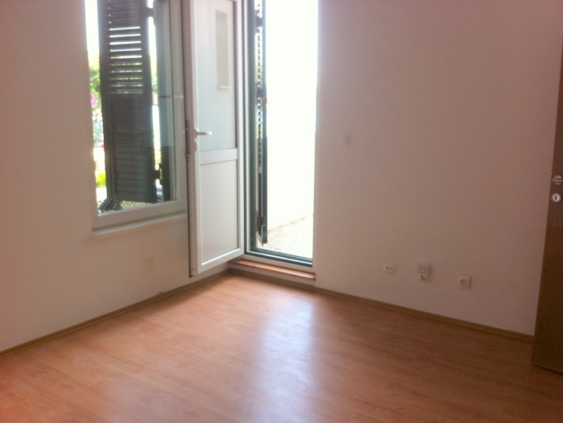 Helles Wohnzimmer mit Laminat und Zugang zur Terrasse in einer Wohnung, Herceg Novi, Montenegro.