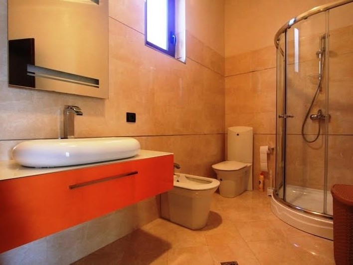 Modernes Badezimmer mit Duschkabine und farbenfrohem Waschtischunterschrank in einer Villa in Petrovac, Montenegro.